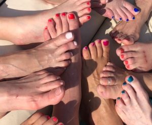 Six women show off their pedicured feet on a boat tour in Italy